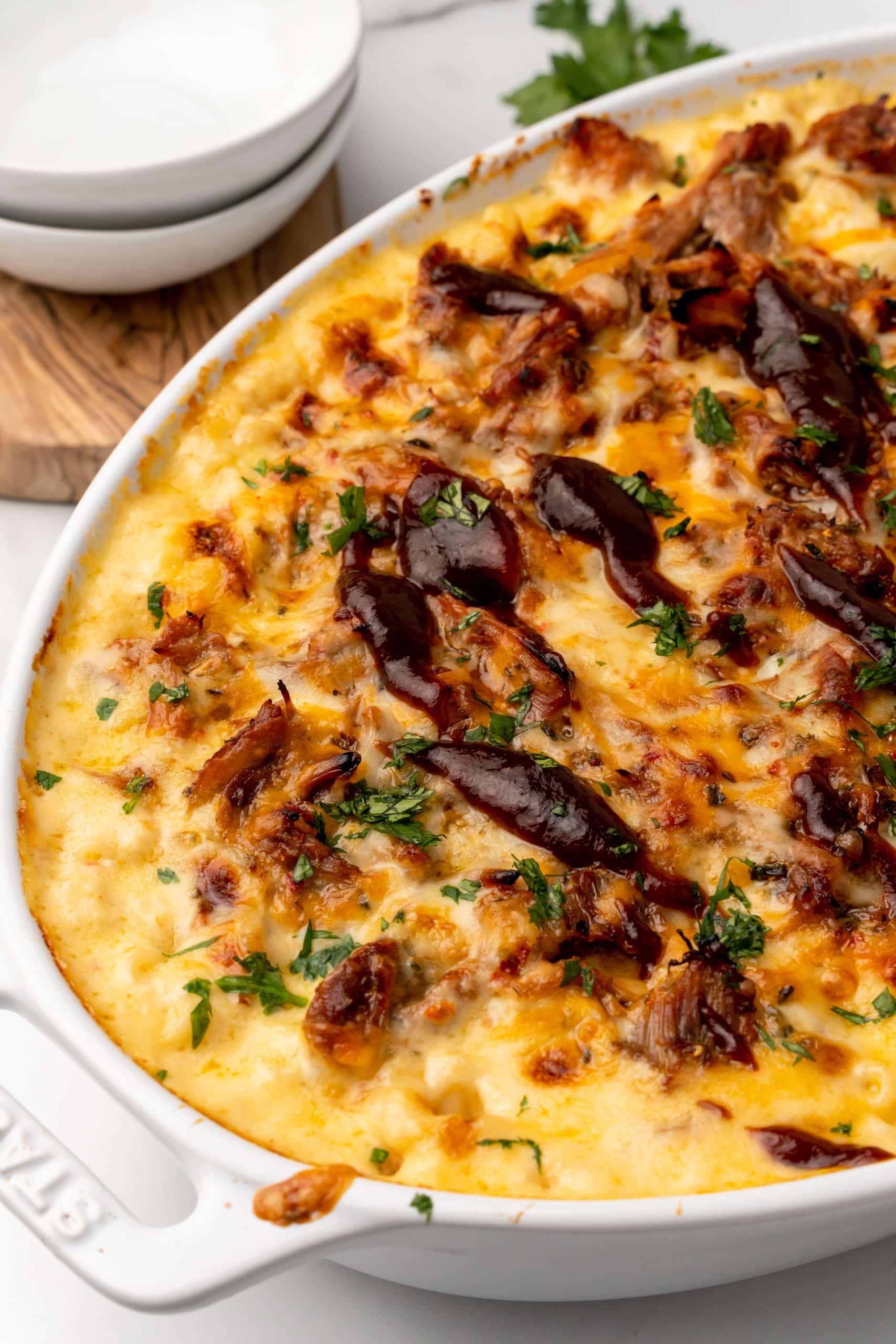 pulled pork mac and cheese in a white casserole dish