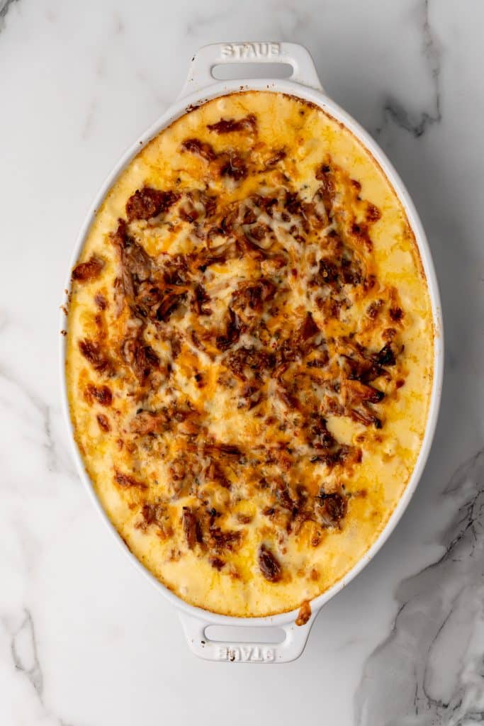 pulled pork mac and cheese in a white casserole dish