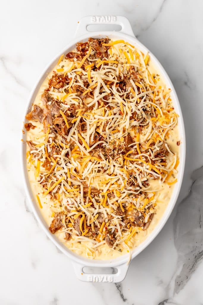 pulled pork mac and cheese in a white casserole dish