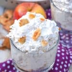 apple pie fluff salad in two glass jars topped with pieces of crumbled pie crust