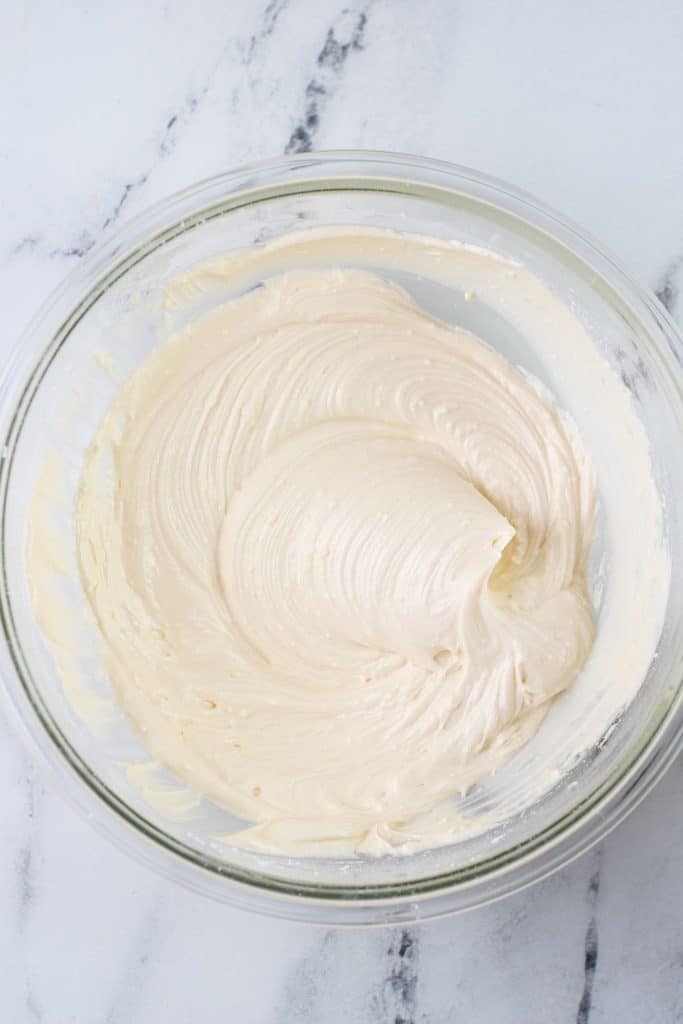 cream cheese frosting in a glass mixing bowl