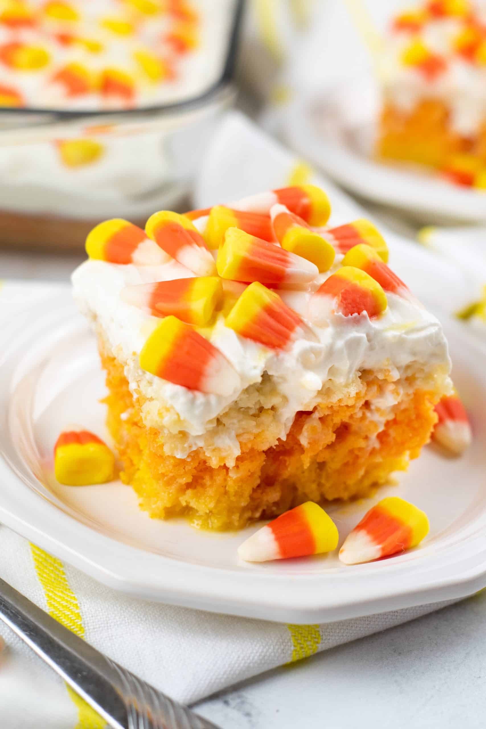 Candy Corn Poke Cake a slice of candy corn poke cake on a white plate