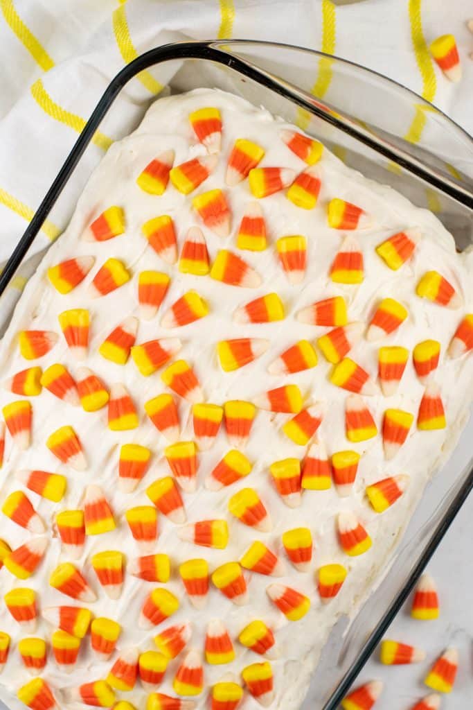a candy corn poke cake in a 9x13" pyrex baking dish