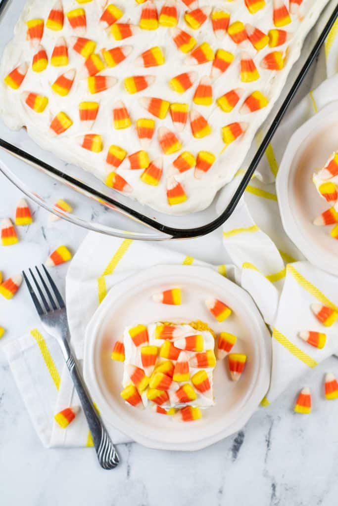 a slice of candy corn poke cake on a white plate