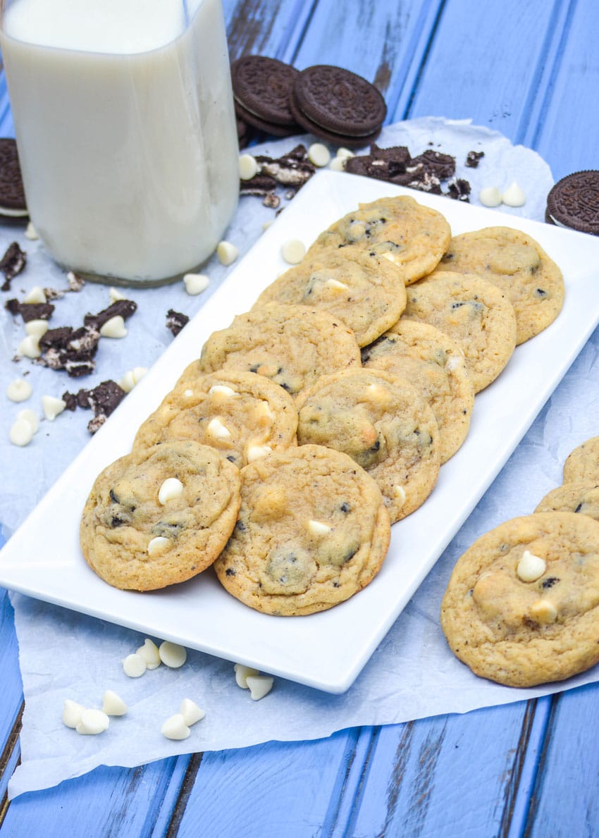 oreo cookies and cream pudding cookies with white chocolate chips arranged in two rows on a white serving platter