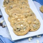 oreo cookies and cream pudding cookies with white chocolate chips arranged in two rows on a white serving platter