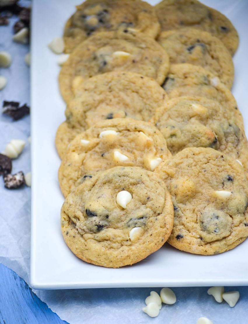 oreo cookies and cream pudding cookies with white chocolate chips arranged in two rows on a white serving platter