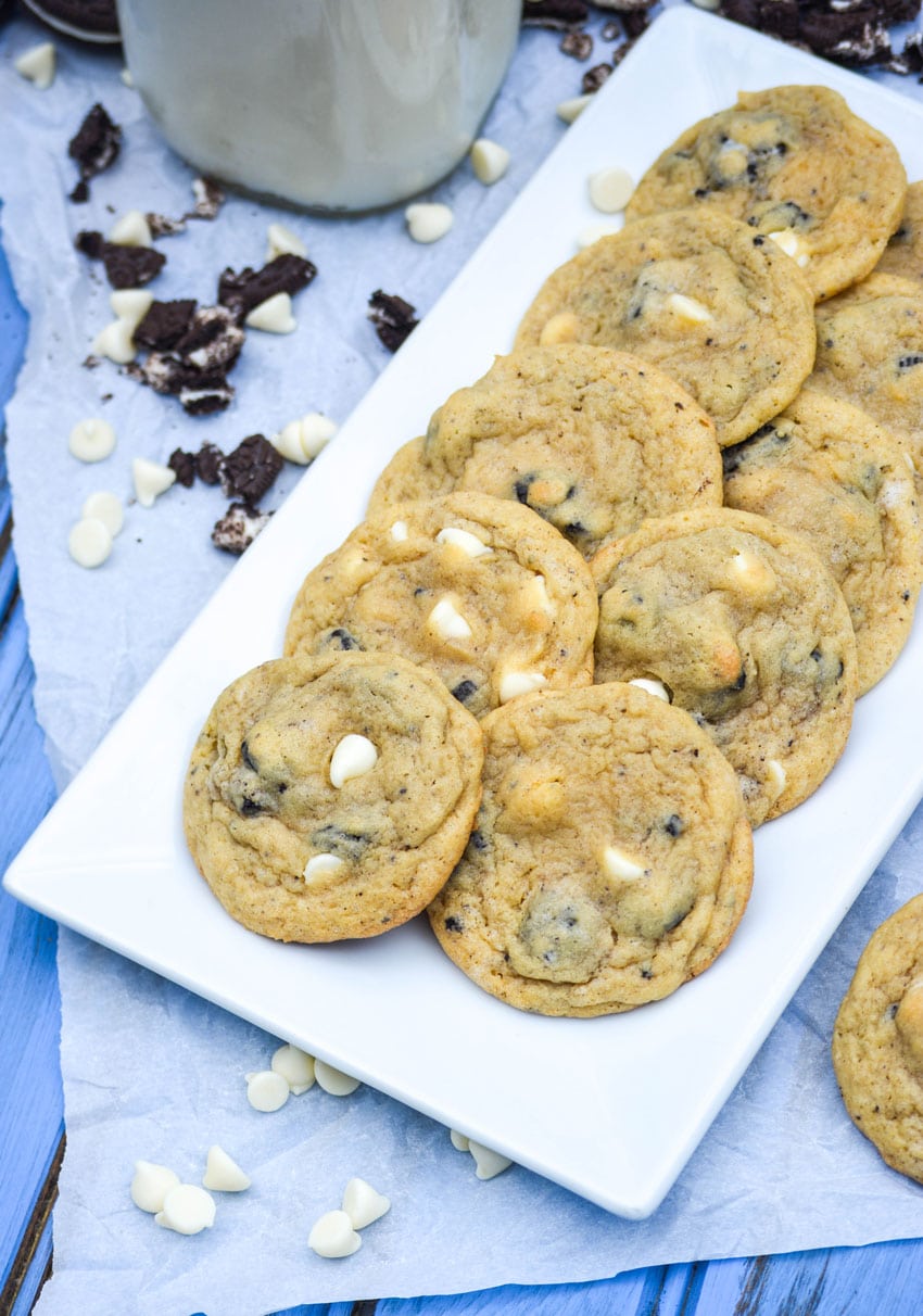 oreo cookies and cream pudding cookies with white chocolate chips arranged in two rows on a white serving platter