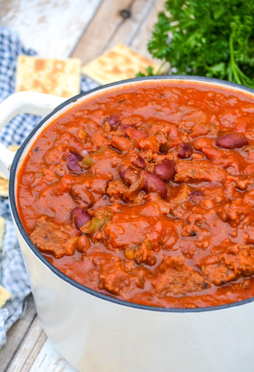 copycat wendy's chili in a small white dutch oven with saltine crackers on the side