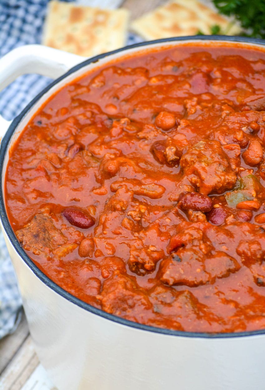 copycat wendy's chili in a small white dutch oven with saltine crackers on the side
