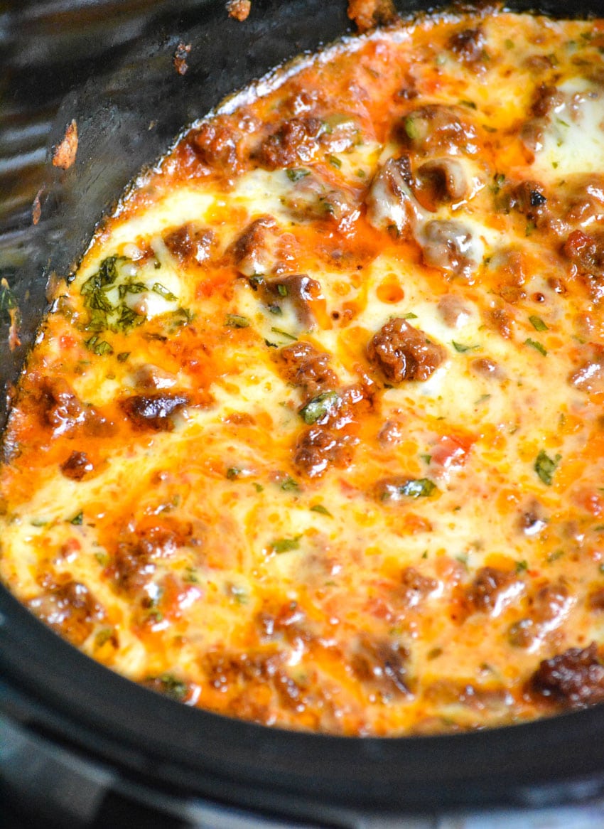 slow cooker queso fundido dip in the black bowl of a crockpot