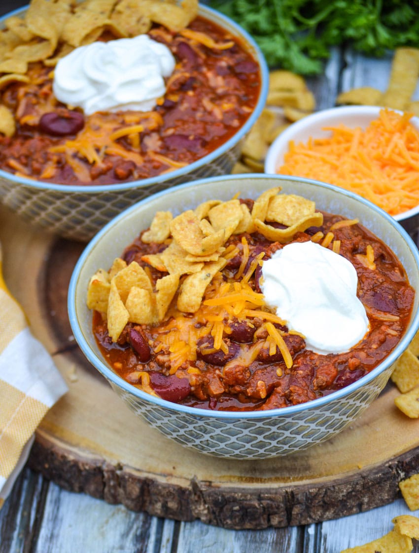 Instant pot chili in two bowls on a wooden cutting board