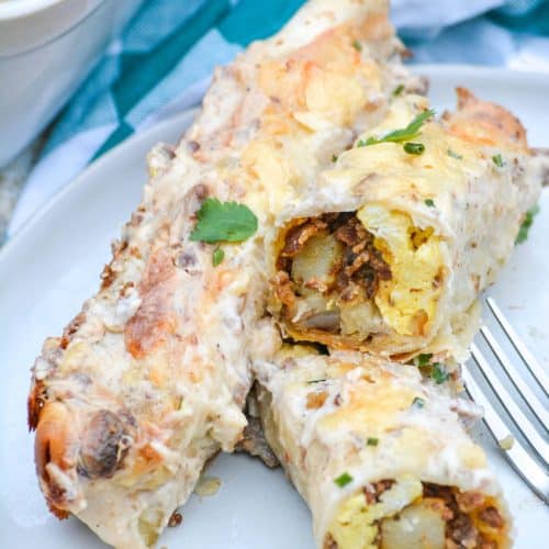 sausage gravy breakfast enchiladas on a white plate