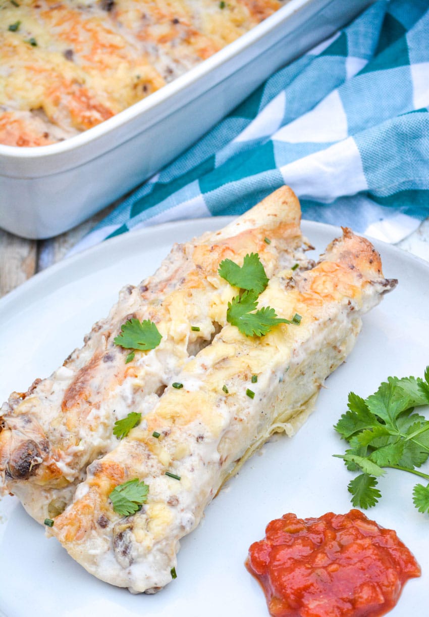 sausage gravy breakfast enchiladas on a white plate