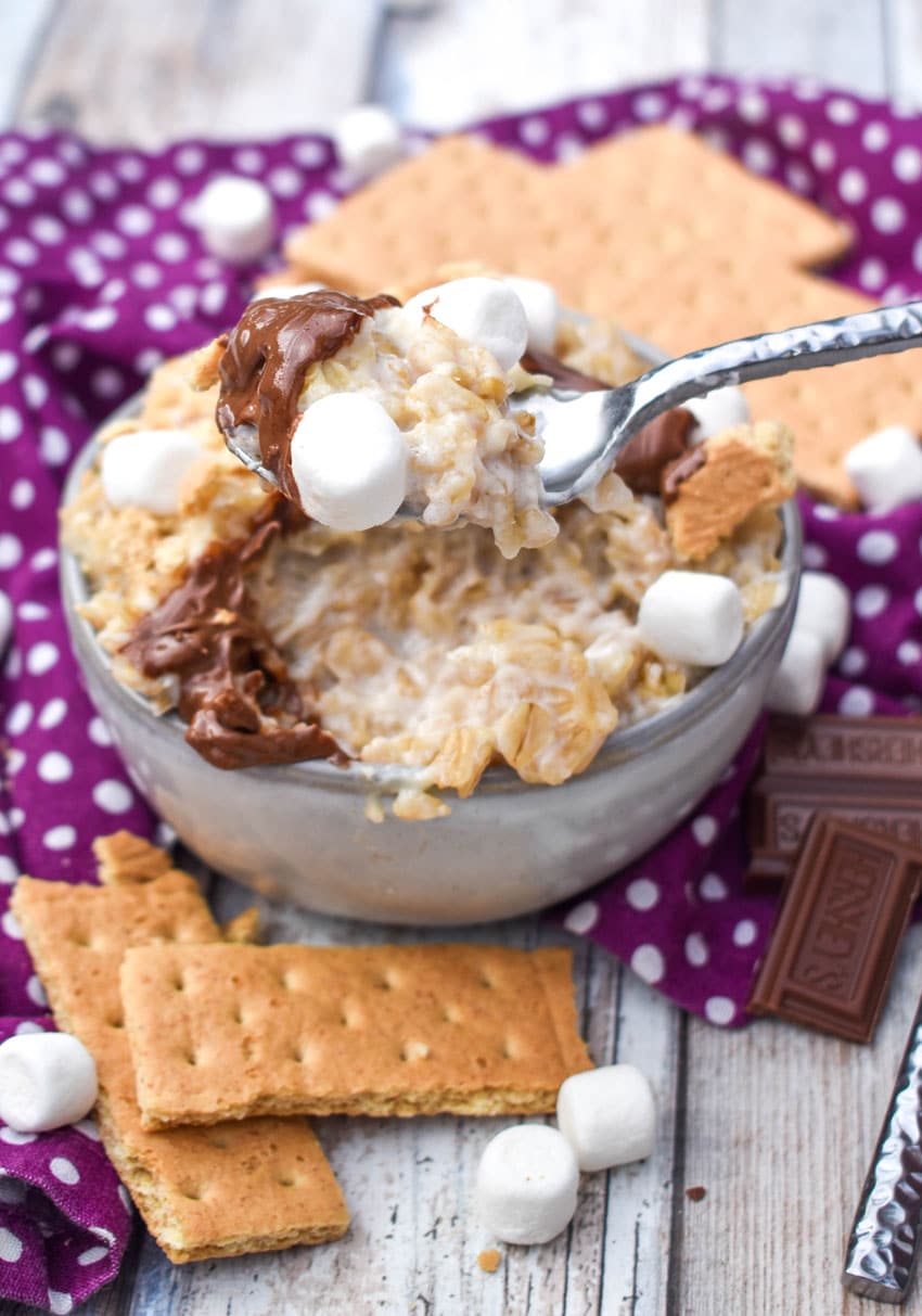 a silver spoon stuck in a small bowl of s'mores oatmeal