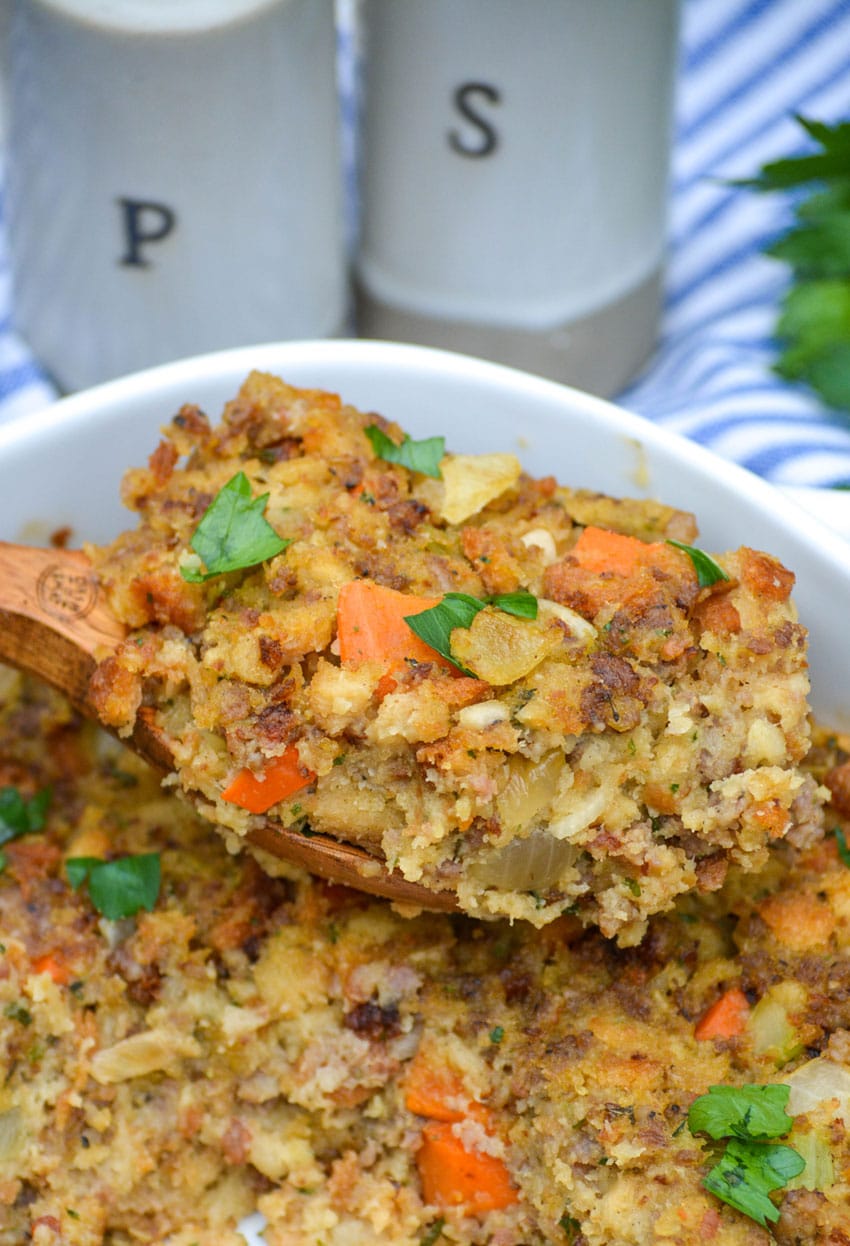 a wooden spoon holding up a scoop of semi homemade stuffing using stove top