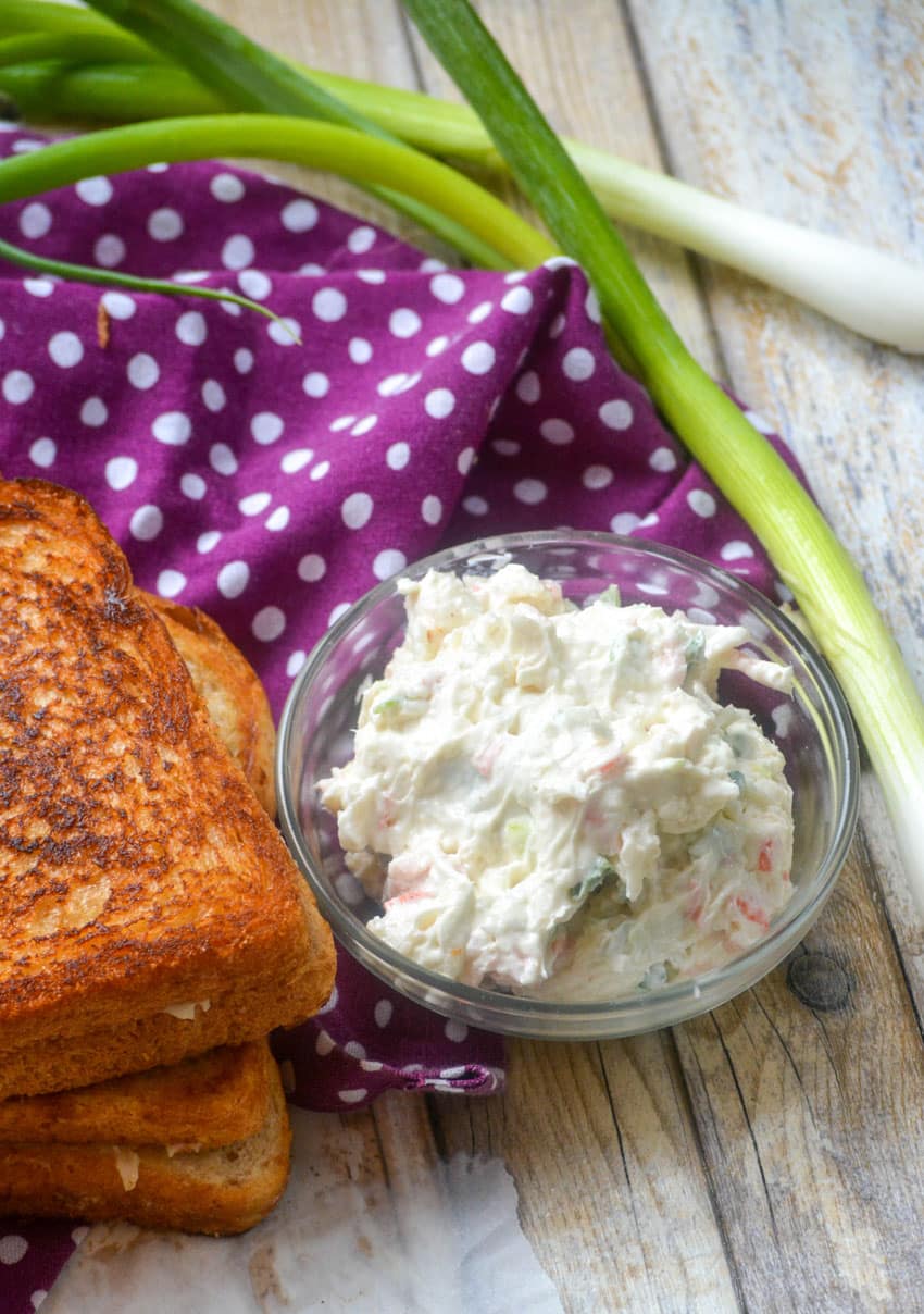 crab rangoon cream cheese mixture in a small glass bowl next to a grilled cheese sandwich