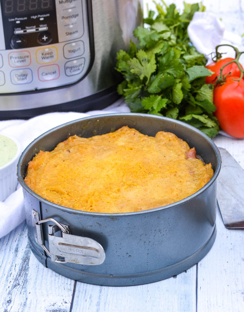 pulled pork stuffed tamale pie in a sprinform pan sitting in front of an instant pot
