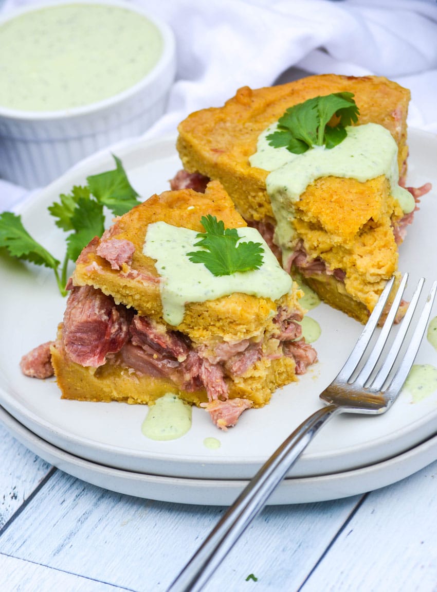 two slices of instant pot tamale pie and a silver fork resting on a white plate