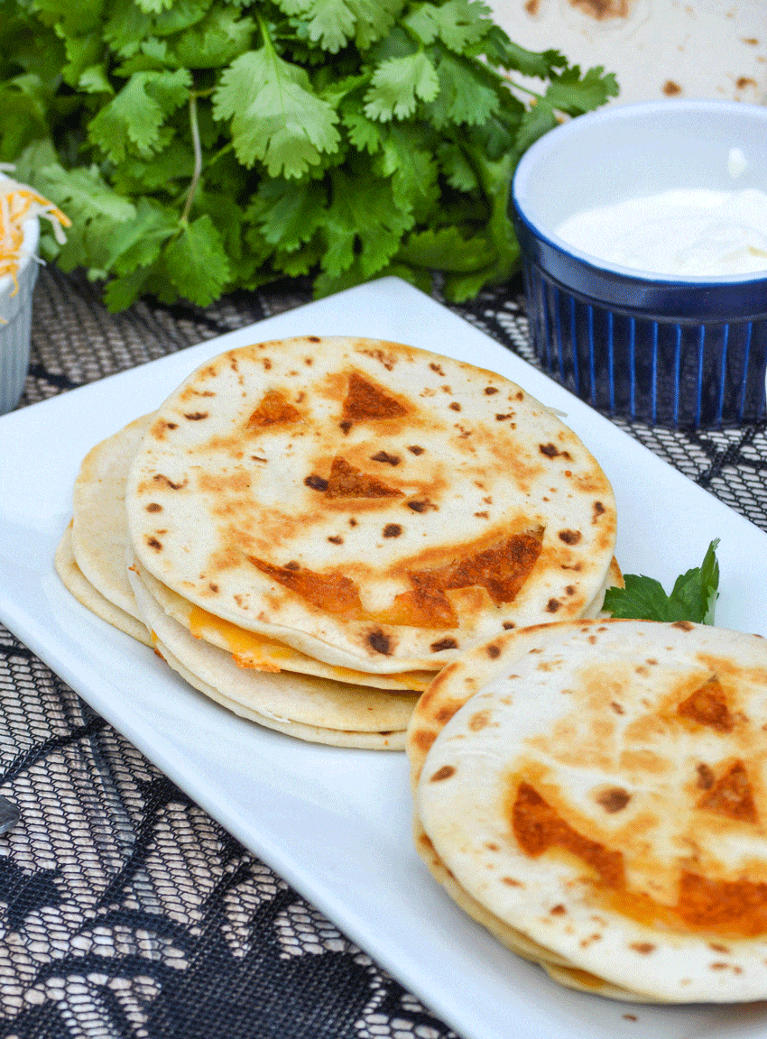 jack 'o lantern quesadillas on a white platter