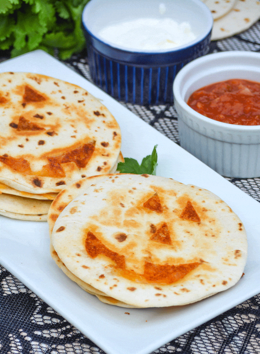 jack 'o lantern quesadillas on a white platter