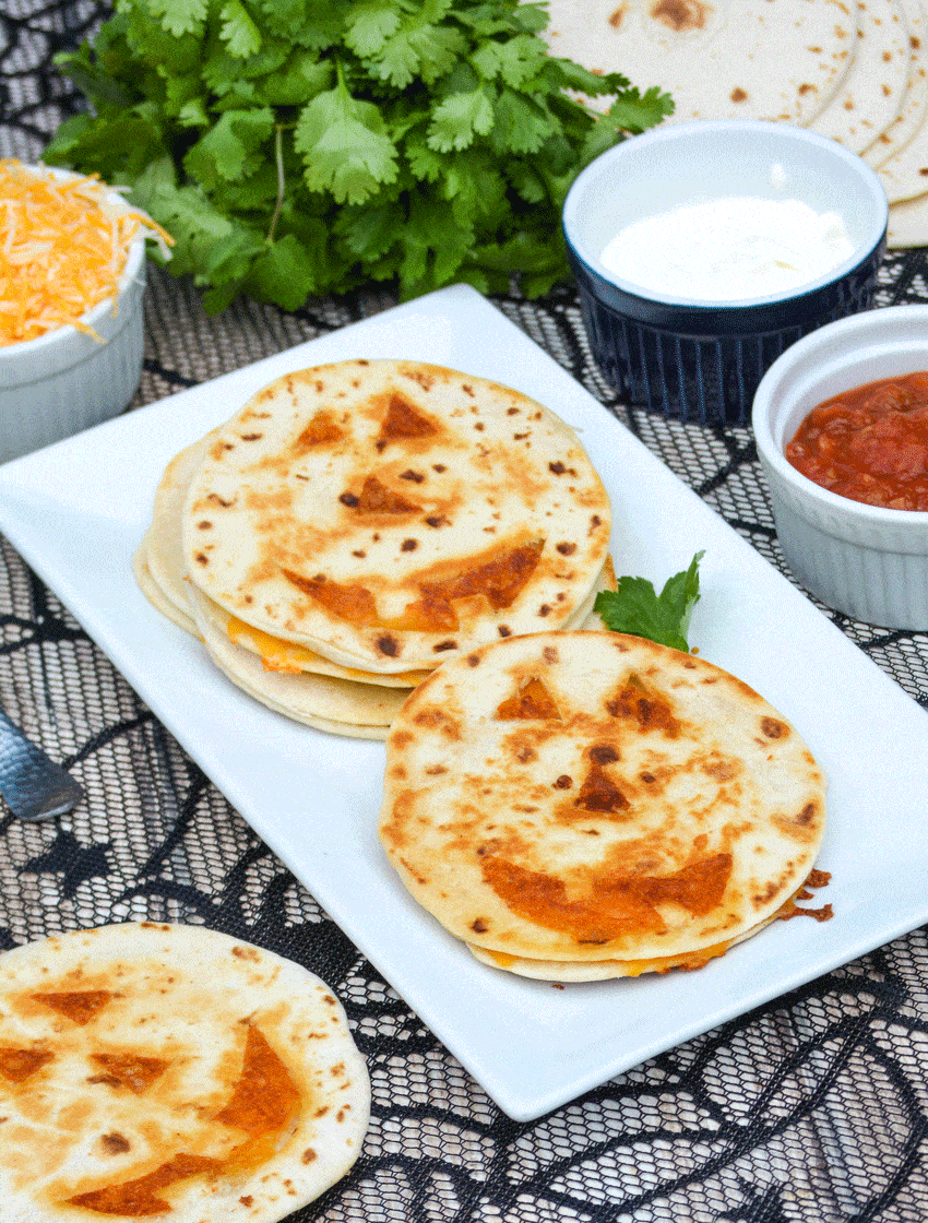 jack 'o lantern quesadillas on a white platter