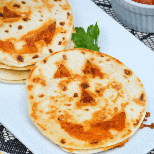 jack 'o lantern quesadillas on a white platter