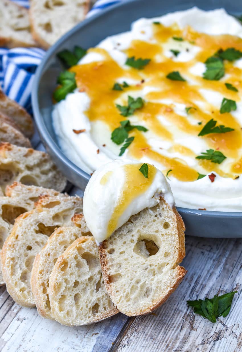 a baguette sliced topped with whipped ricotta cheese dip spread