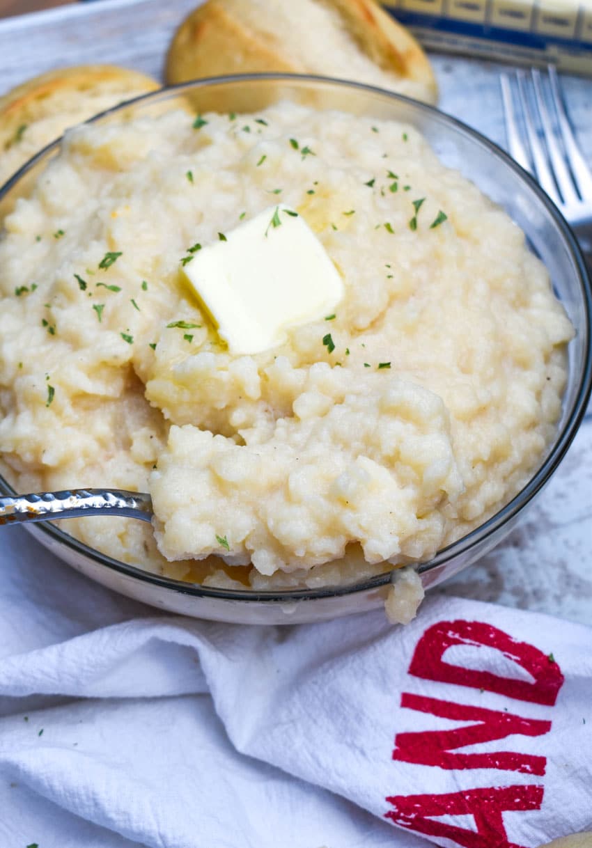 a silver fork in a glass bowl filled with creamy canned mashed potatoes