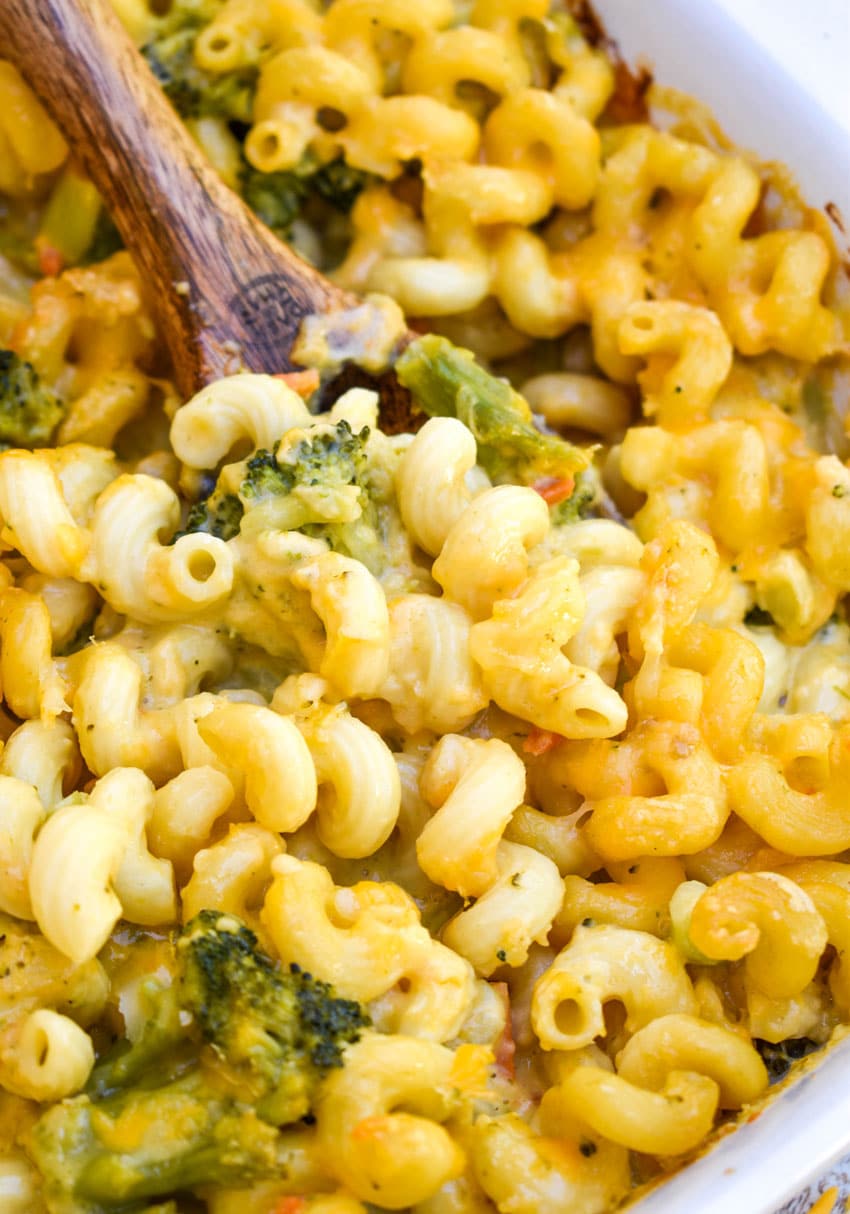 Broccoli Cheddar Mac & Cheese (Panera Bread Copycat) a wooden spoon in a casserole dish of creamy broccoli cheddar mac and cheese