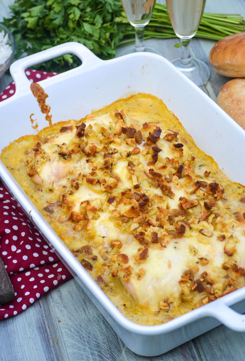 a white casserole dish filled with herb crusted chicken in wine sauce