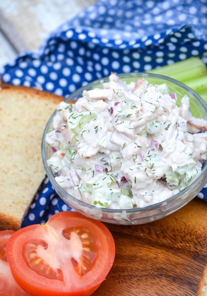 creamy leftover turkey salad in a small glass bowl on a wooden cutting board