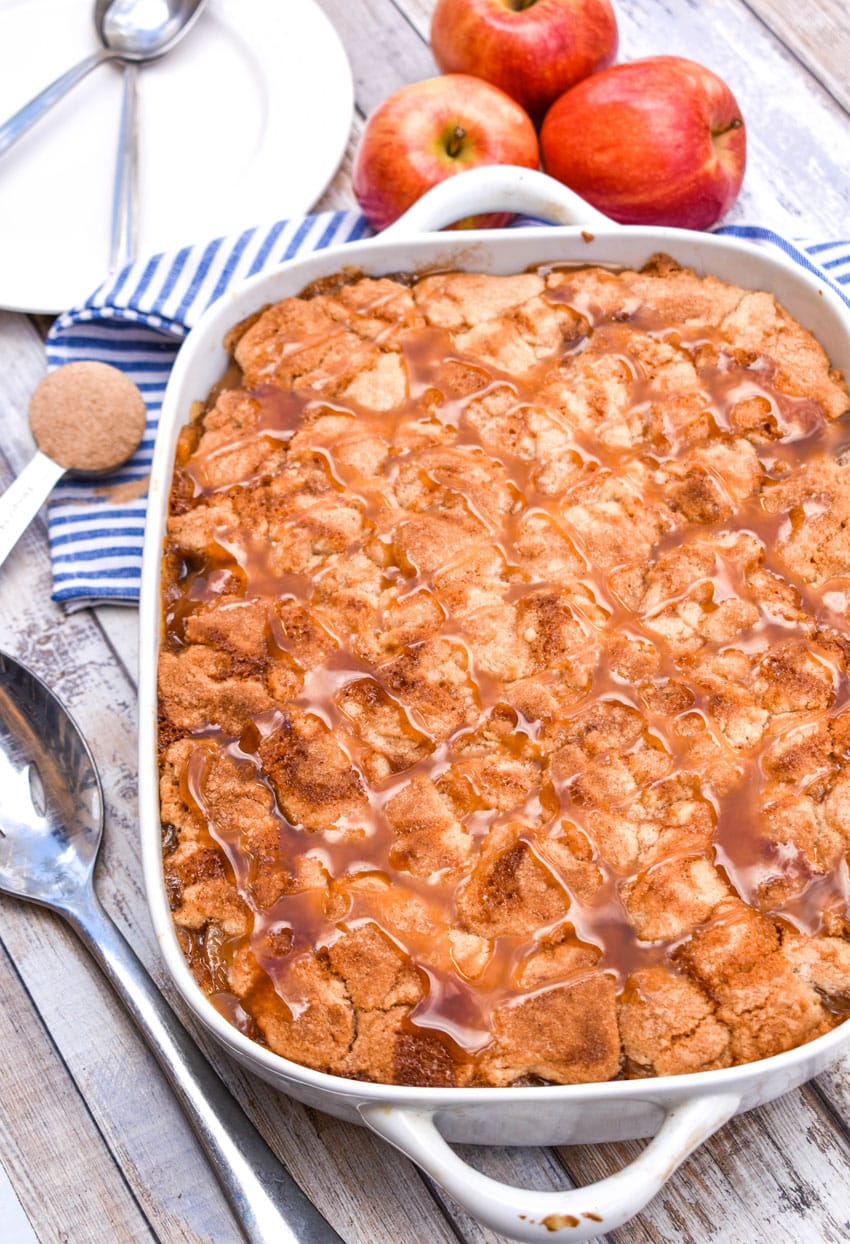 caramel sauce topped snickerdoodle apple cobbler in a white baking dish