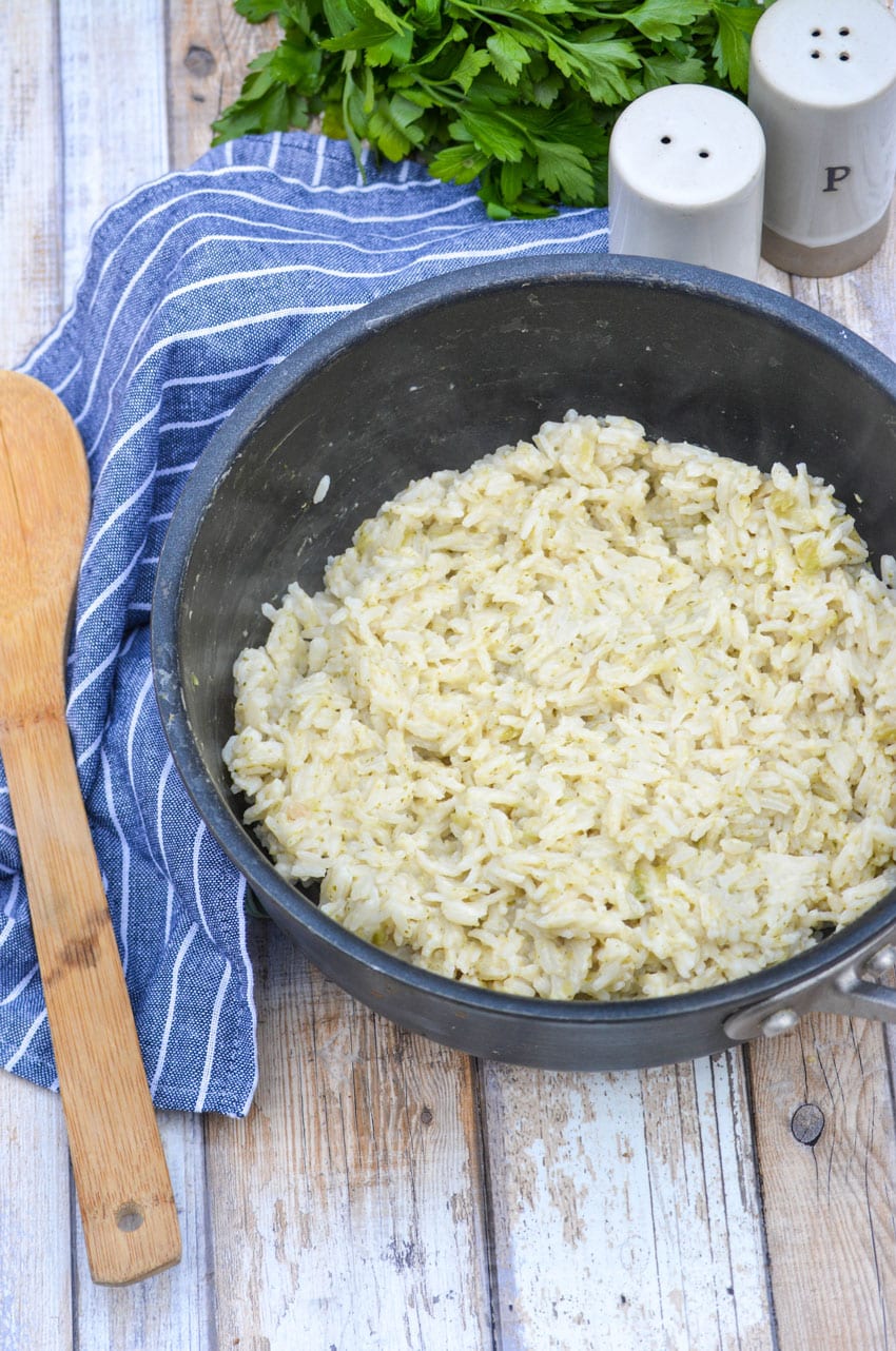 3 ingredient savory rice in a black pot with a wooden spoon on the side