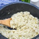 souper rice in a black pot with a wooden spoon