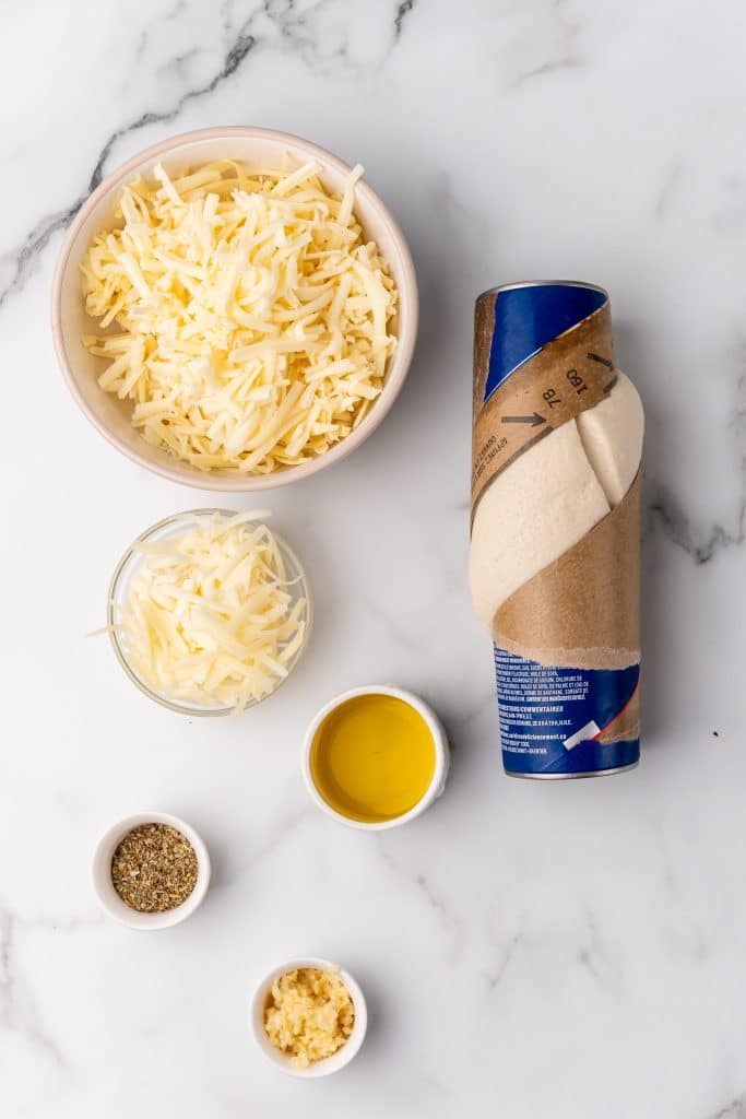 overhead image showing the measured ingredients needed to make a batch of cheesy garlic breadsticks