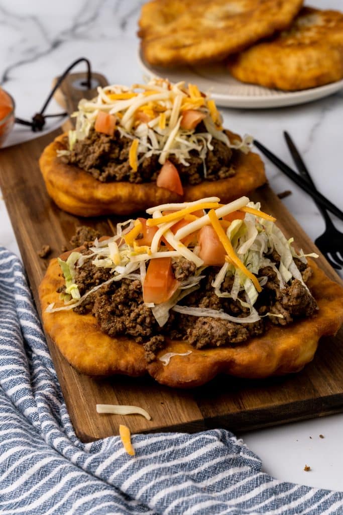 navajo tacos on indian fry bread on a wooden cutting board