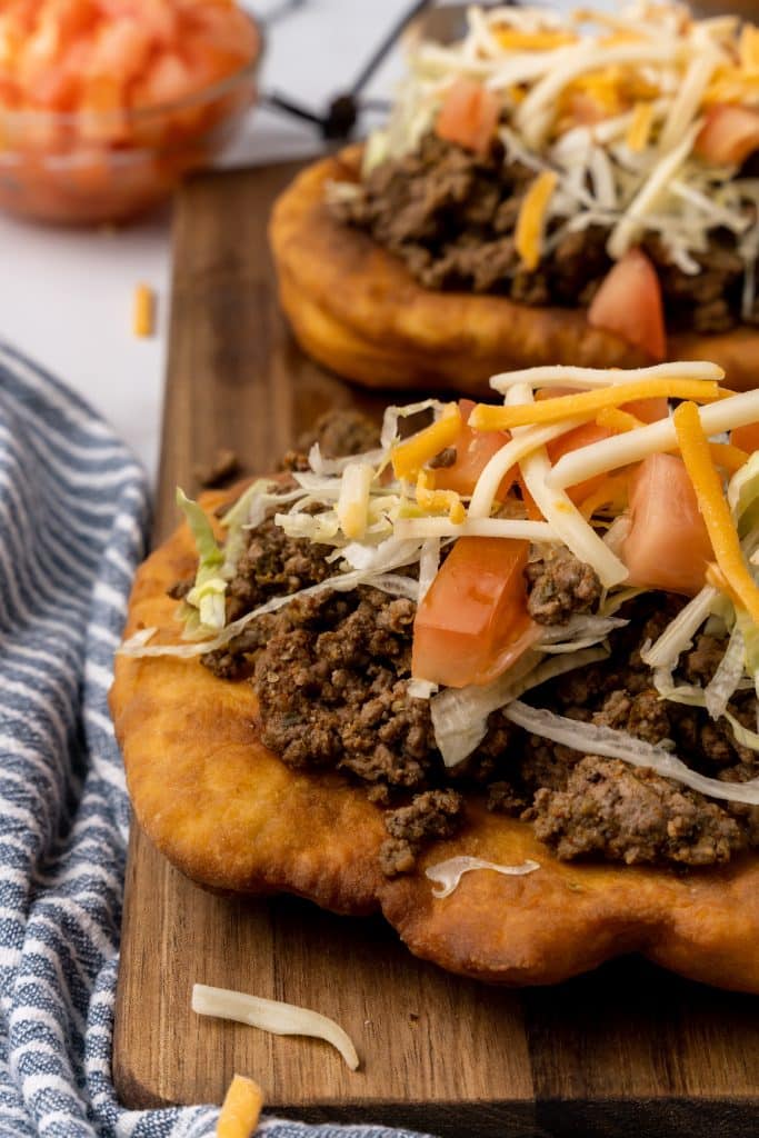 navajo tacos on indian fry bread on a wooden cutting board