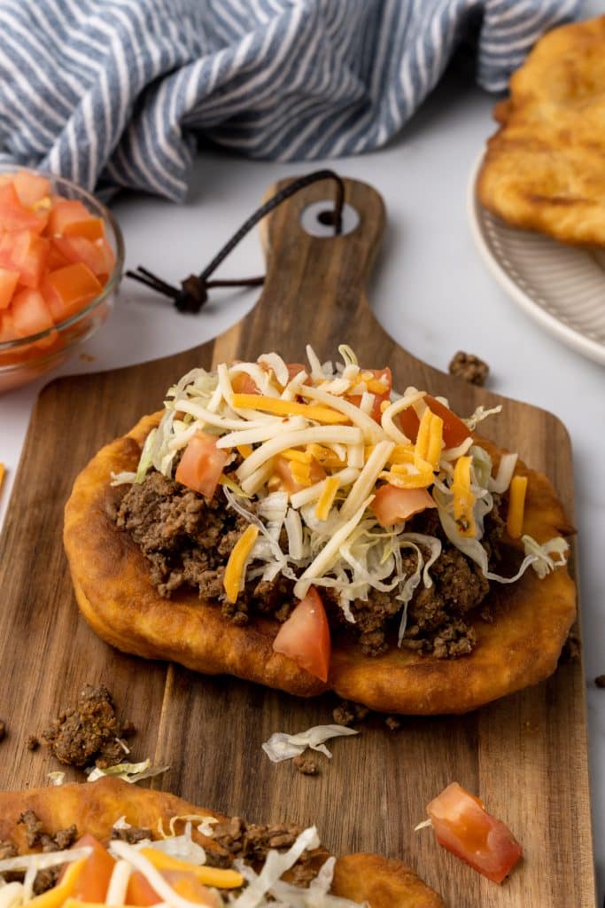 navajo tacos on indian fry bread on a wooden cutting board