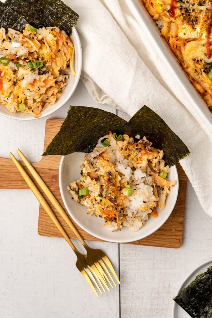 tiktok salmon sushi bake in two white bowls with pieces of seaweed as garnish