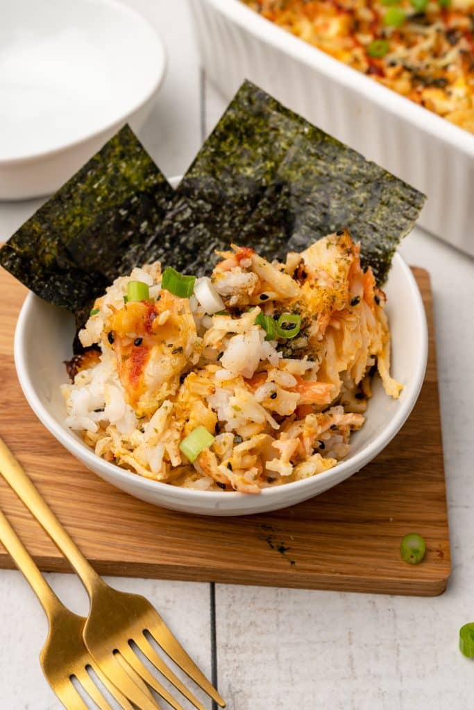 tiktok salmon sushi bake in a white bowl sitting on a wooden cutting board