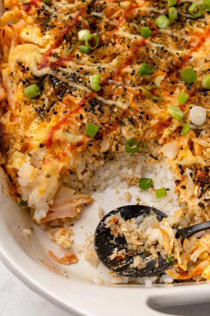 a black spoon in a baked sushi casserole
