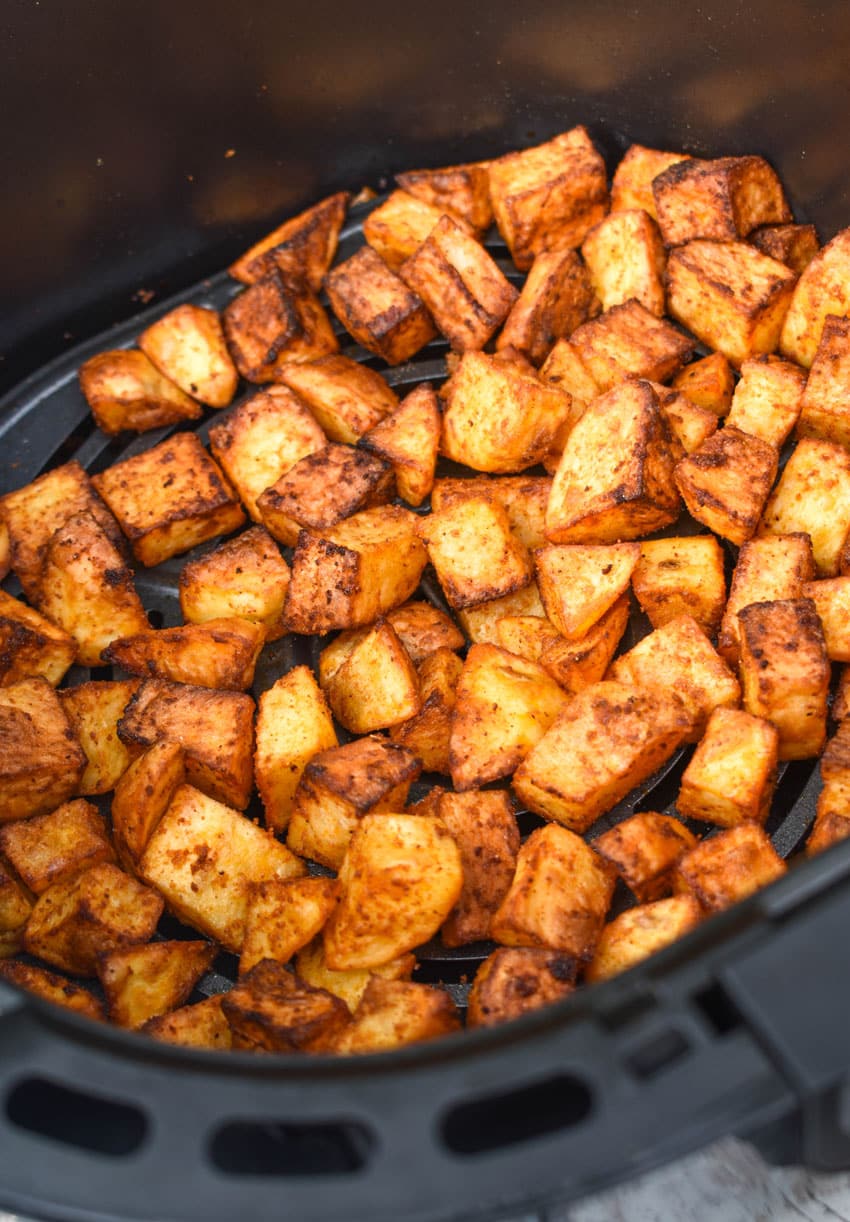 crispy breakfast potatoes in the basket of an air fryer