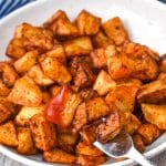 crispy air fryer breakfast potatoes in a shallow white bowl with a silver fork