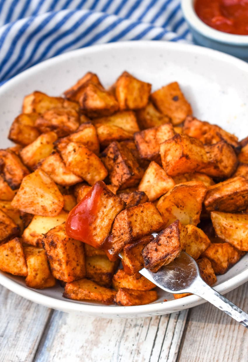 crispy air fryer breakfast potatoes in a shallow white bowl with a silver fork
