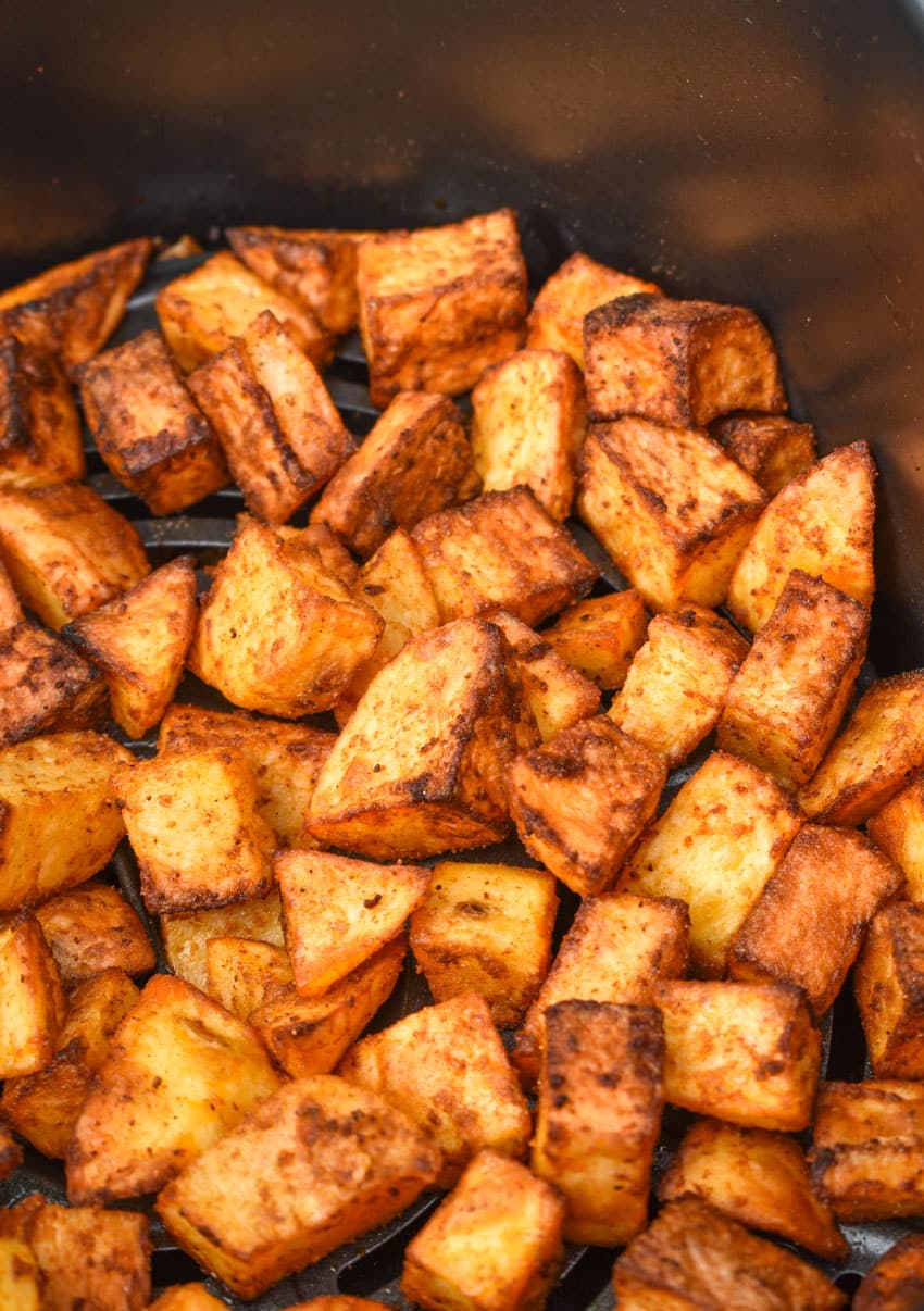 crispy breakfast potatoes in the basket of an air fryer