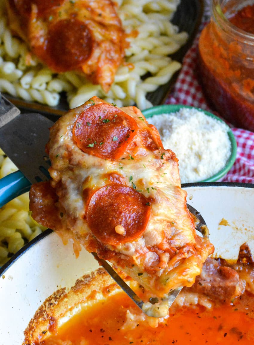 a spatula holding up a piece of baked pizza chicken