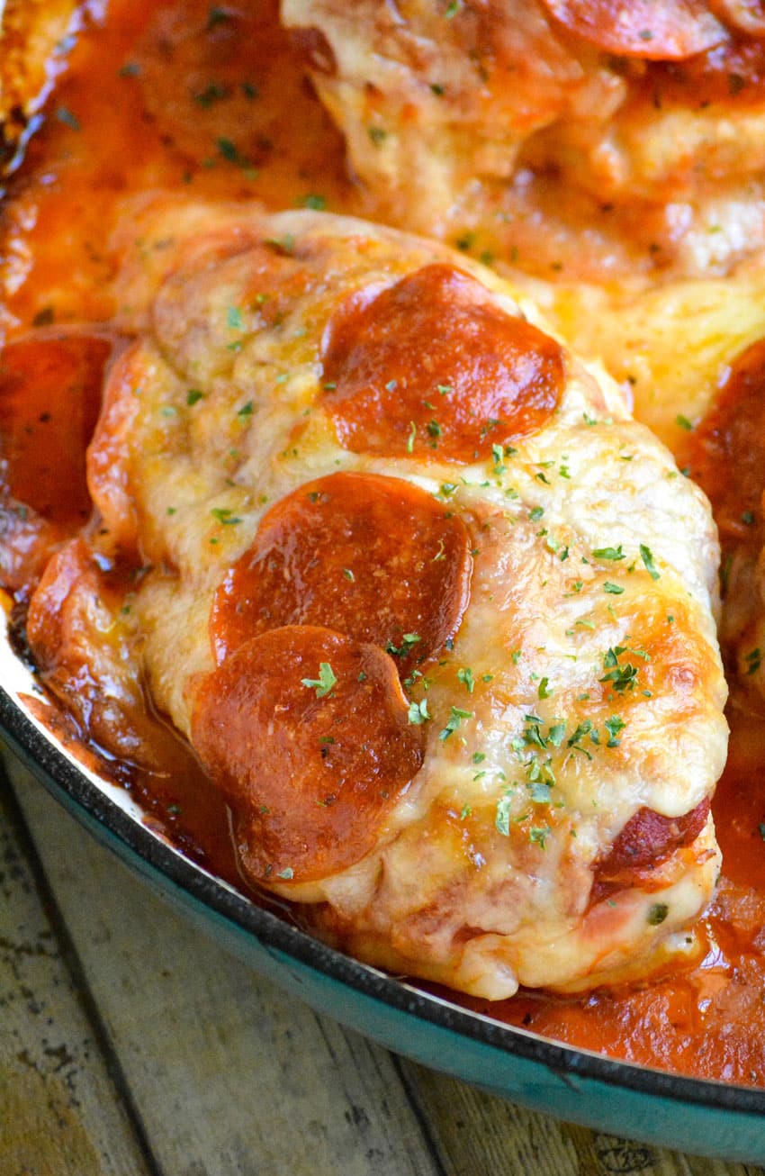 a piece of easy pizza chicken topped with cheese and pepperoni in a cast iron skillet