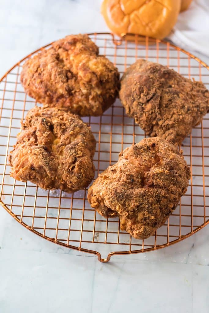 copycat popeyes fried chicken breasts on a metal cooling rack