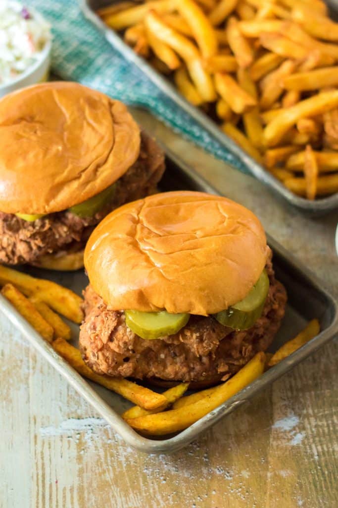 copycat popeyes chicken sandwiches on a metal tray with french fries